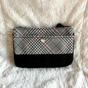 Black/white with red accent stripe wristlet. Outside button close slip pocket.